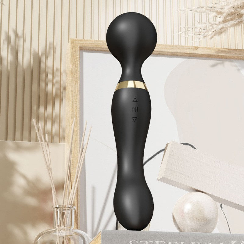 Black handheld device with gold accent on a neutral background